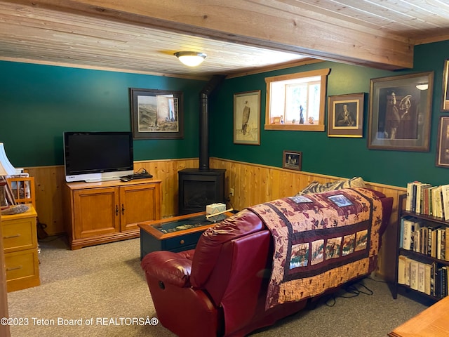 carpeted bedroom with a wood stove and wooden ceiling