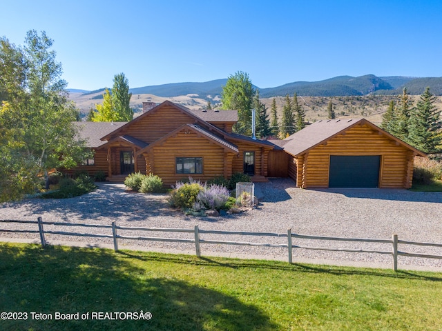 log home featuring a front yard, a mountain view, and a garage