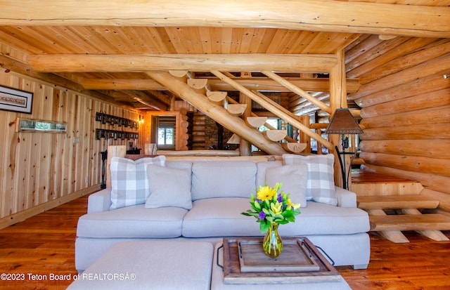 living room with wooden ceiling, rustic walls, dark wood-type flooring, and beamed ceiling