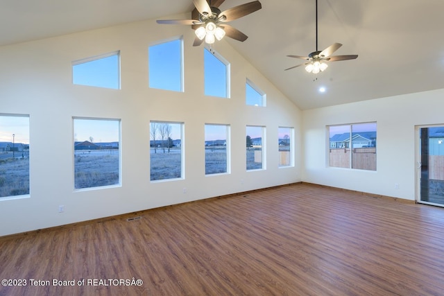 unfurnished living room with high vaulted ceiling, hardwood / wood-style floors, ceiling fan, and plenty of natural light