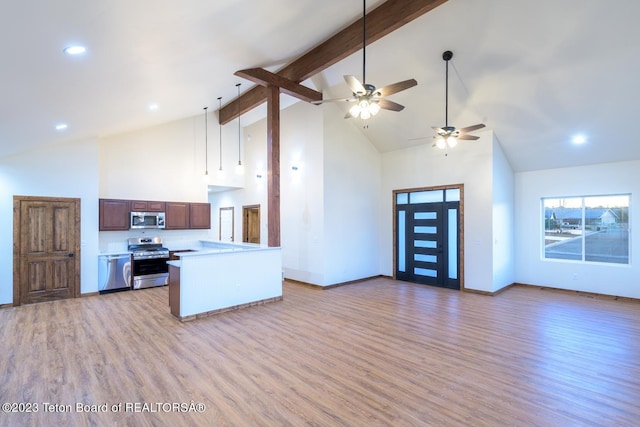 kitchen with beamed ceiling, light hardwood / wood-style flooring, appliances with stainless steel finishes, high vaulted ceiling, and ceiling fan