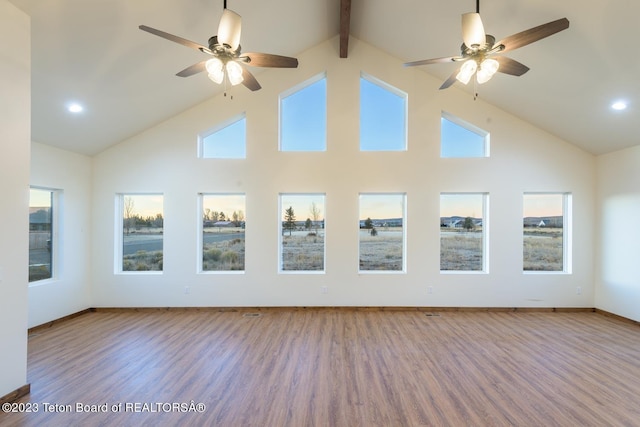 unfurnished sunroom featuring ceiling fan and vaulted ceiling with beams