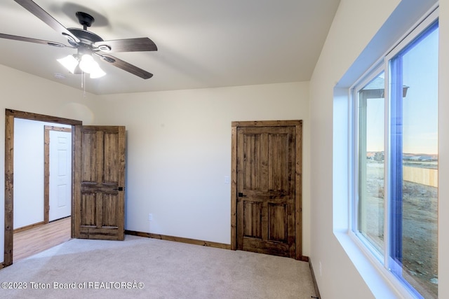 unfurnished bedroom featuring light colored carpet and ceiling fan