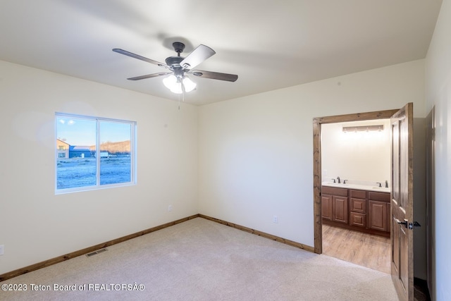 carpeted spare room featuring sink and ceiling fan