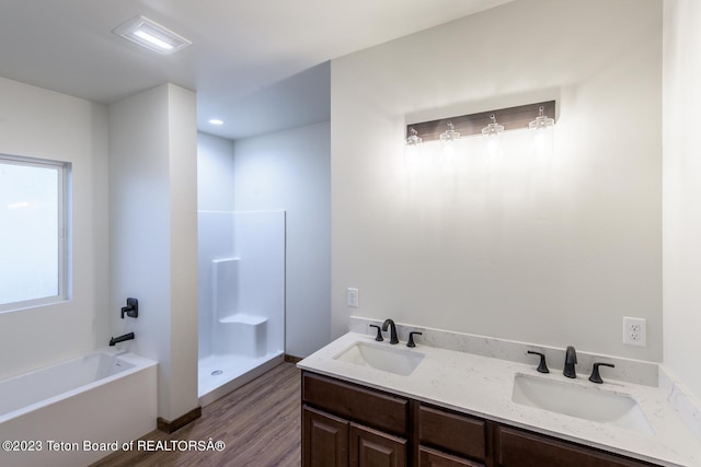 bathroom featuring vanity, hardwood / wood-style floors, and plus walk in shower