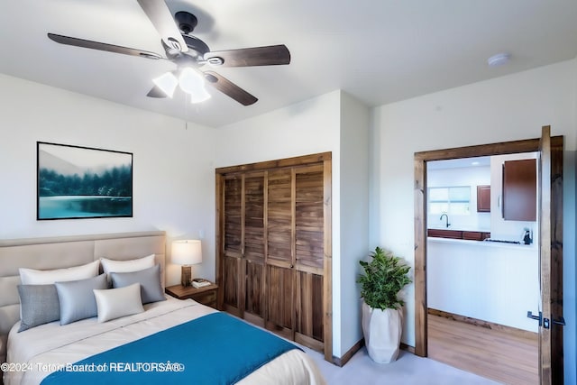 bedroom featuring sink, ceiling fan, and a closet