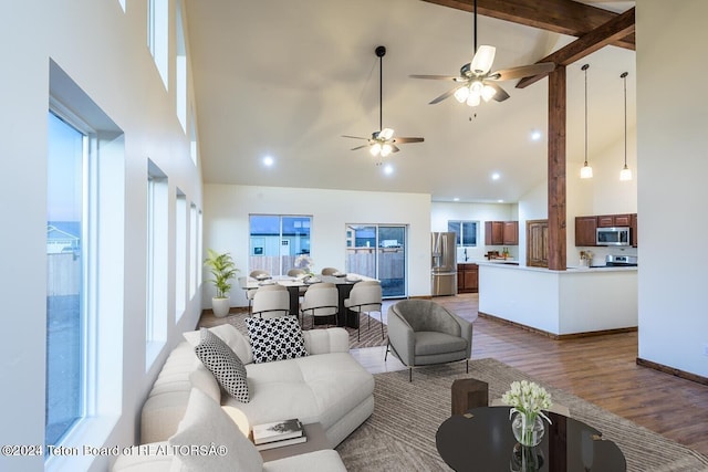 living room with high vaulted ceiling, hardwood / wood-style flooring, ceiling fan, and beamed ceiling