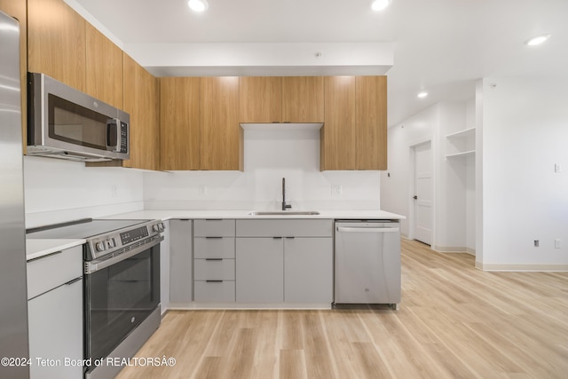 kitchen featuring light wood-type flooring, appliances with stainless steel finishes, and sink