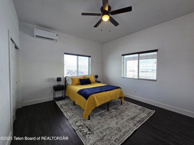 bedroom featuring a wall mounted air conditioner, dark wood finished floors, a ceiling fan, and baseboards