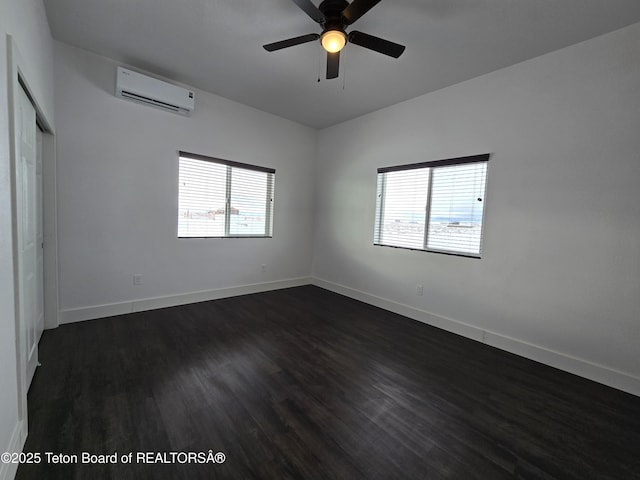 spare room with dark wood-style floors, ceiling fan, baseboards, and a wall mounted AC