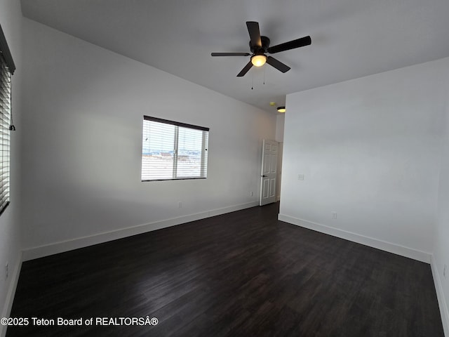 empty room with ceiling fan, dark wood-type flooring, and baseboards