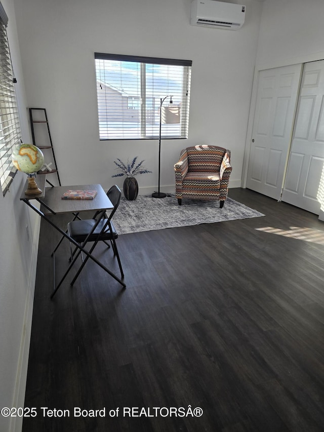 unfurnished room with dark wood-style floors, a wall mounted air conditioner, and baseboards