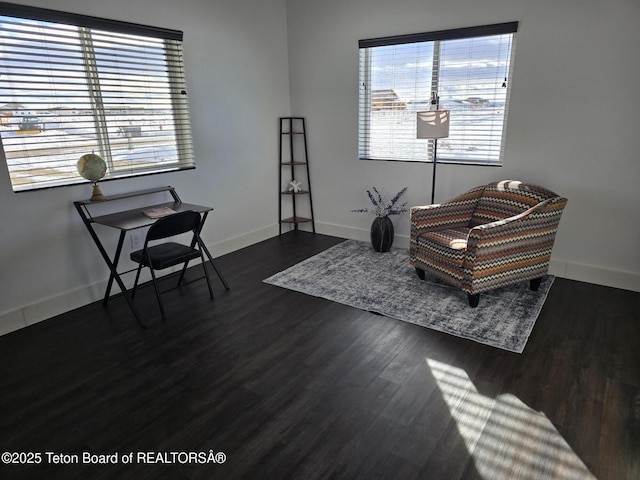 living area featuring dark wood-style floors, a wealth of natural light, and baseboards