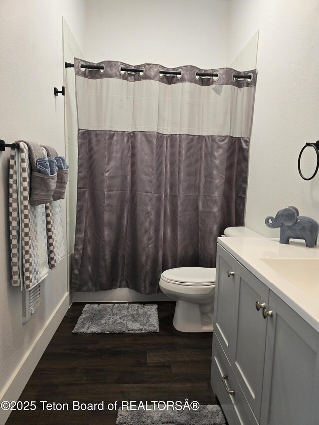 bathroom with toilet, wood finished floors, and vanity