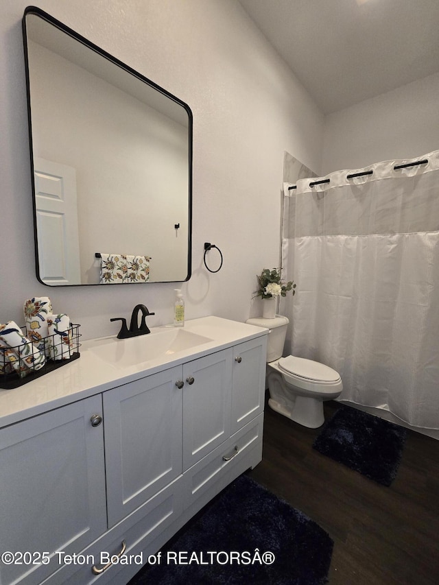 bathroom featuring vanity, toilet, and wood finished floors