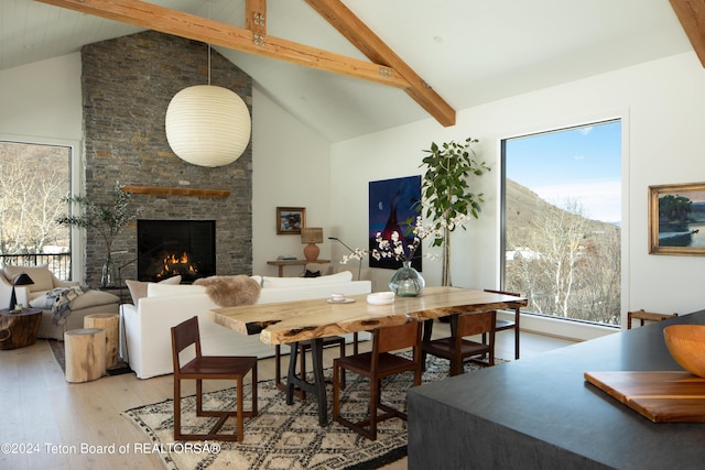 dining space featuring a healthy amount of sunlight, high vaulted ceiling, and beamed ceiling