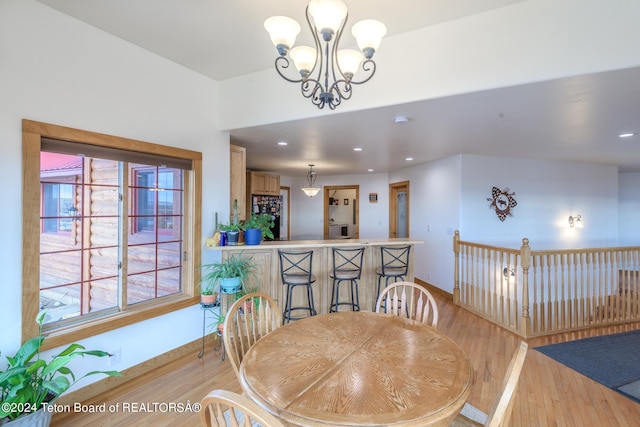 dining area featuring a notable chandelier and light wood-type flooring