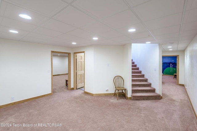 basement featuring light colored carpet and a drop ceiling