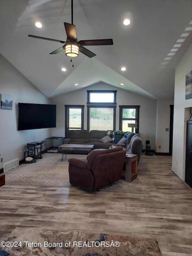 living room featuring ceiling fan, light wood-type flooring, and vaulted ceiling