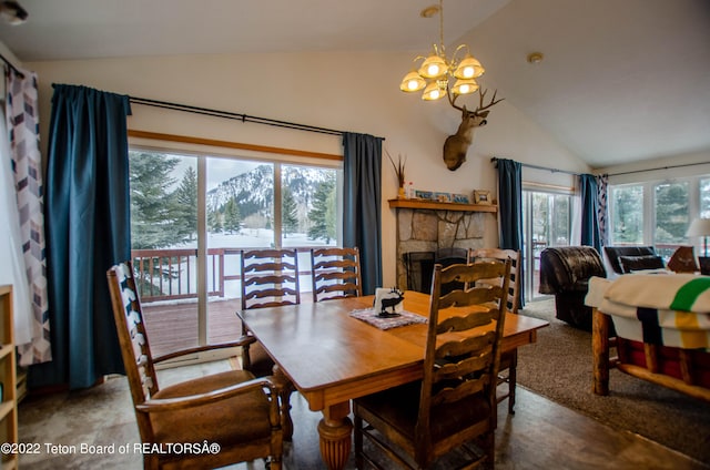 carpeted dining room featuring a stone fireplace, lofted ceiling, and a chandelier