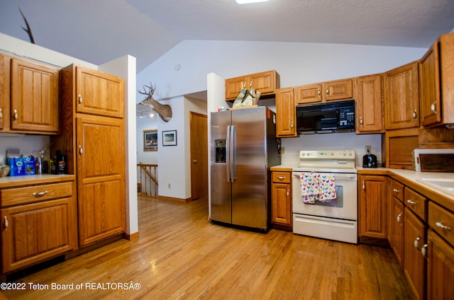 kitchen with white electric range, vaulted ceiling, light hardwood / wood-style floors, and stainless steel fridge with ice dispenser