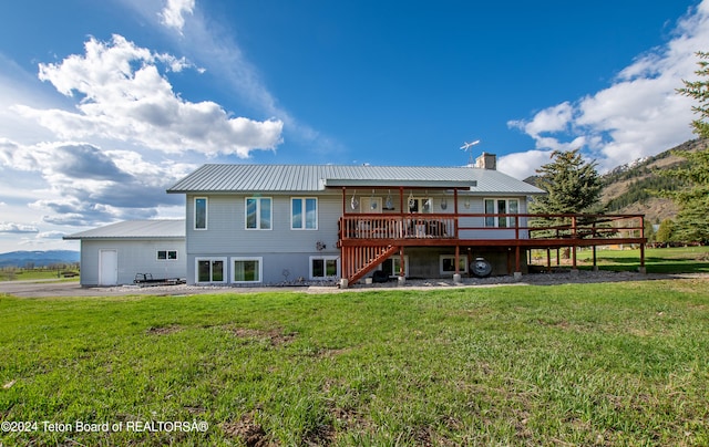 back of house with a wooden deck and a lawn