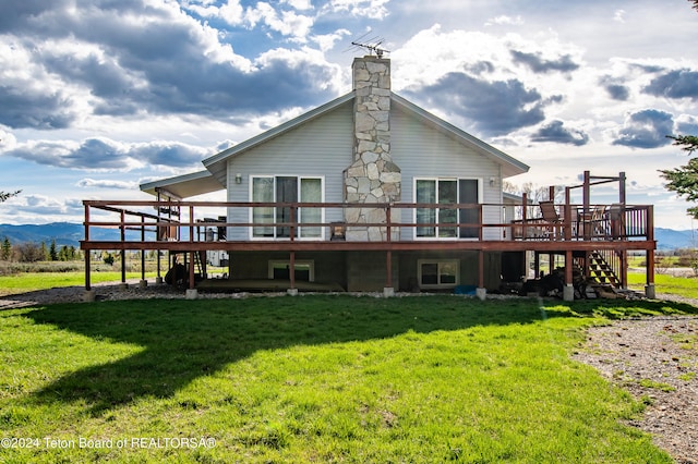 rear view of property with a deck and a yard