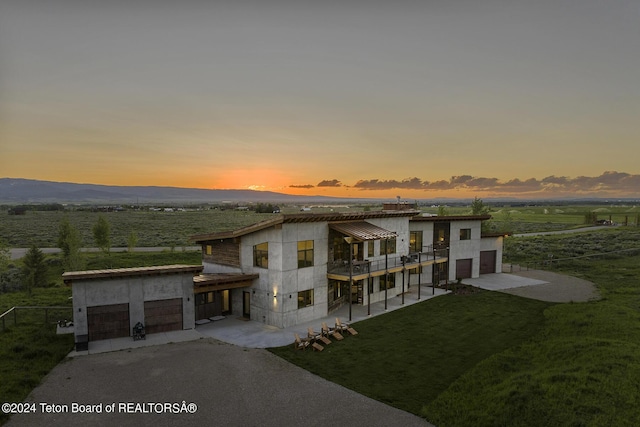 modern home with a mountain view, a yard, and a balcony