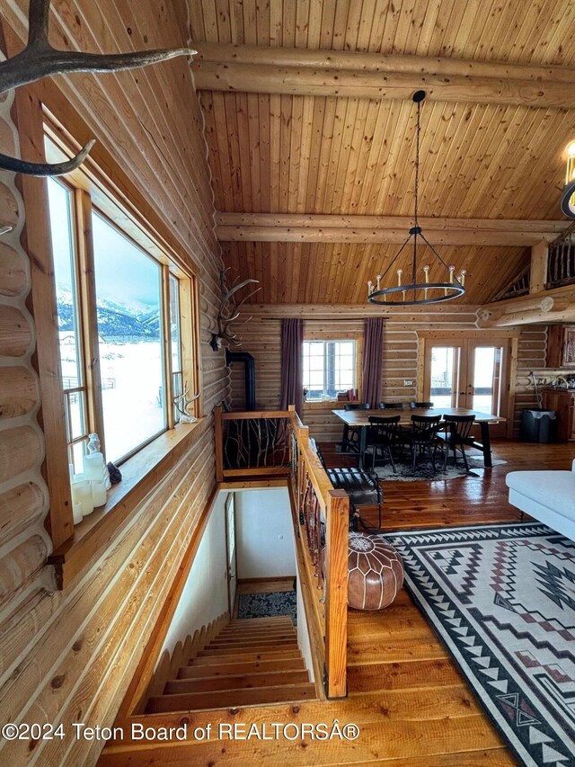 kitchen featuring log walls, hanging light fixtures, wood ceiling, and hardwood / wood-style floors