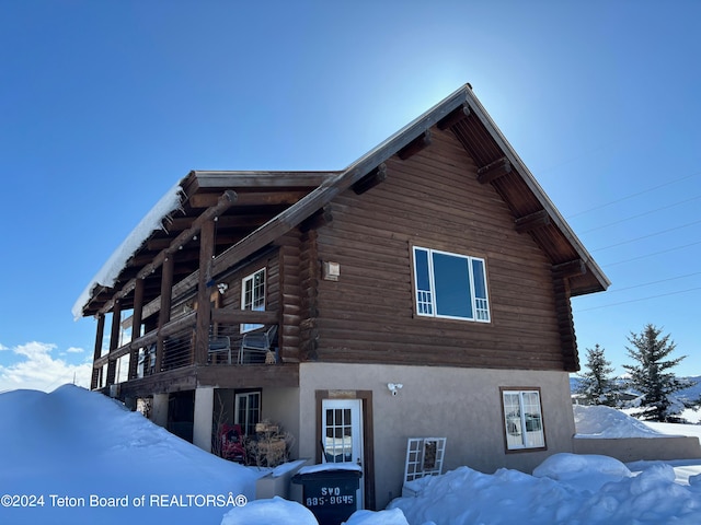 view of snow covered exterior featuring a balcony