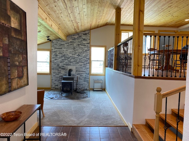 living room featuring wood ceiling, a wealth of natural light, and a wood stove