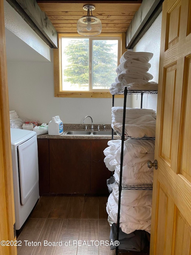 laundry room featuring dark hardwood / wood-style floors, sink, wooden ceiling, washer / clothes dryer, and cabinets
