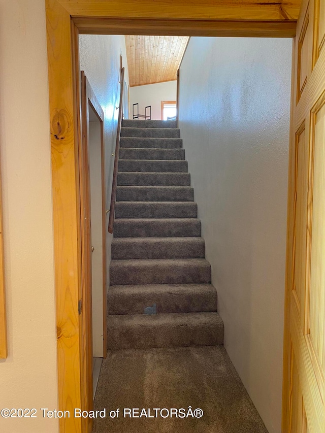 staircase featuring wood ceiling, carpet floors, and vaulted ceiling