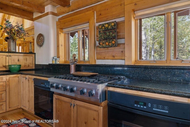 5 W Blair Rd, Alta, WY 83414 - kitchen with oven, stainless steel gas stovetop, beamed ceiling, light hardwood / wood-style flooring, and dark stone counters
