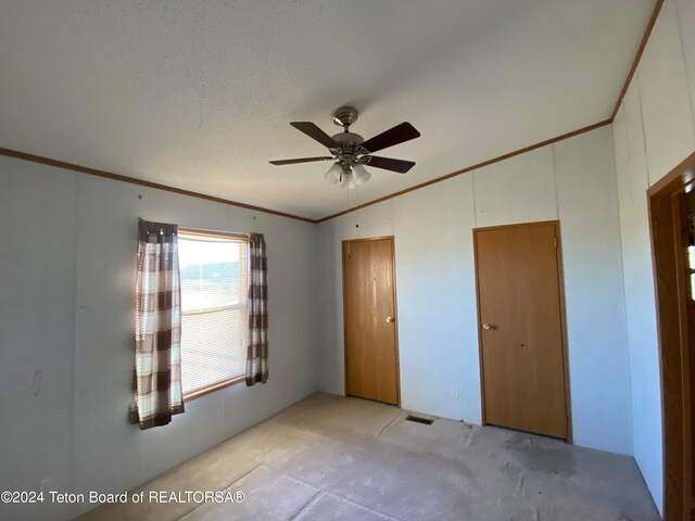 unfurnished bedroom with ceiling fan, crown molding, light carpet, and a textured ceiling