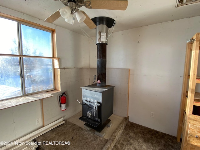 details with a wood stove and ceiling fan