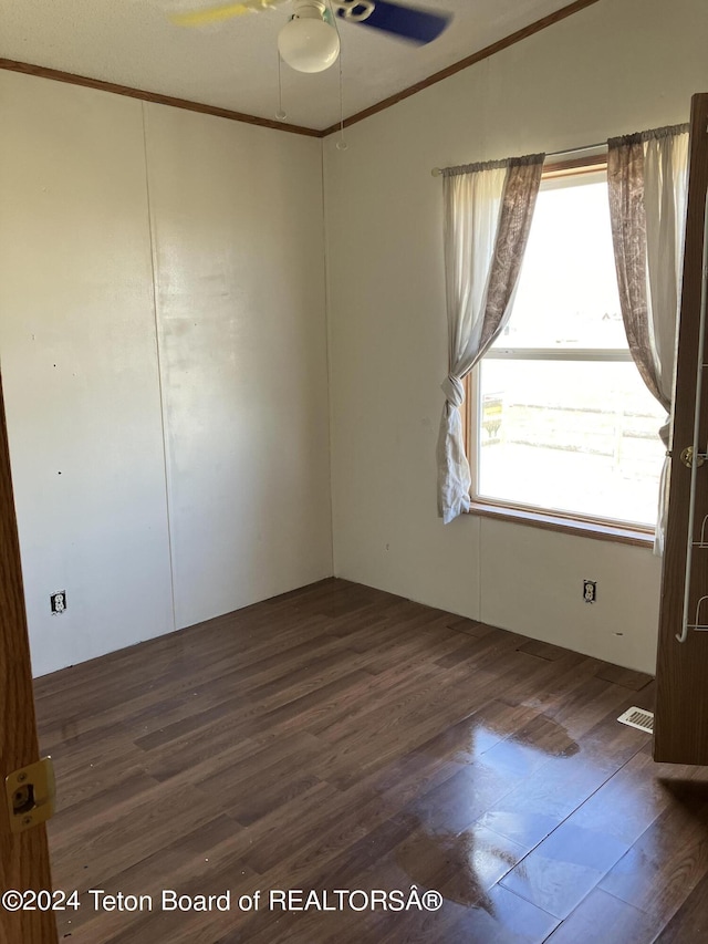 spare room featuring dark hardwood / wood-style floors, ceiling fan, and crown molding