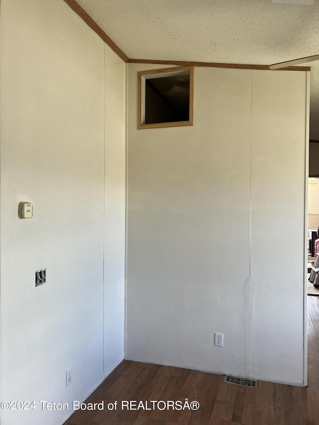 interior space with crown molding, dark wood-type flooring, and a textured ceiling