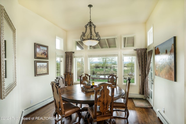 dining room with a baseboard heating unit and dark wood-type flooring