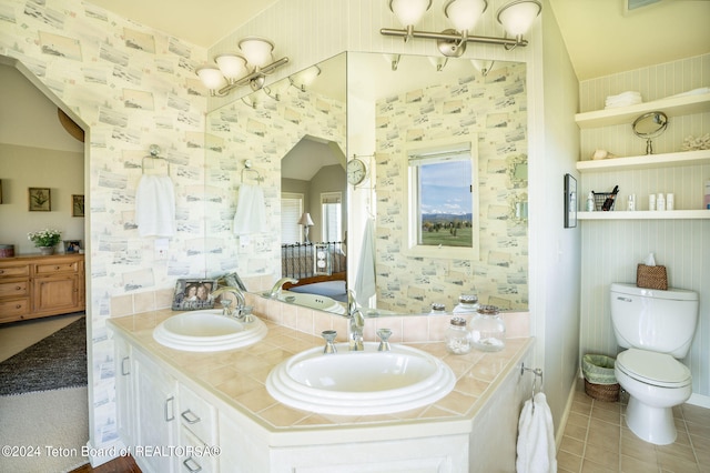 bathroom featuring double sink vanity, tile floors, and toilet