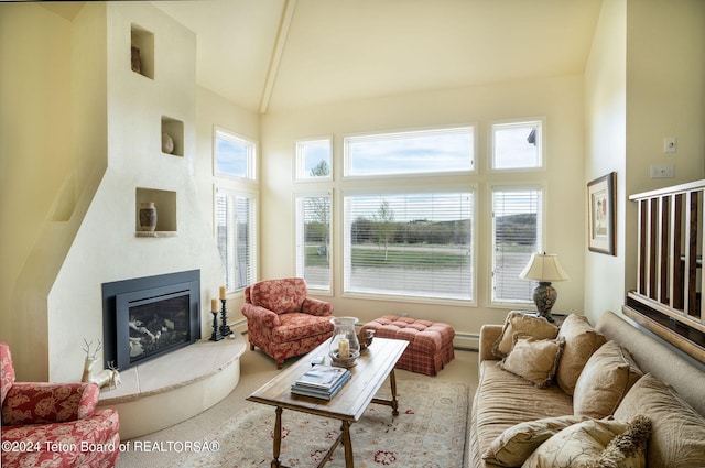 living room featuring light carpet, high vaulted ceiling, a healthy amount of sunlight, and a baseboard radiator