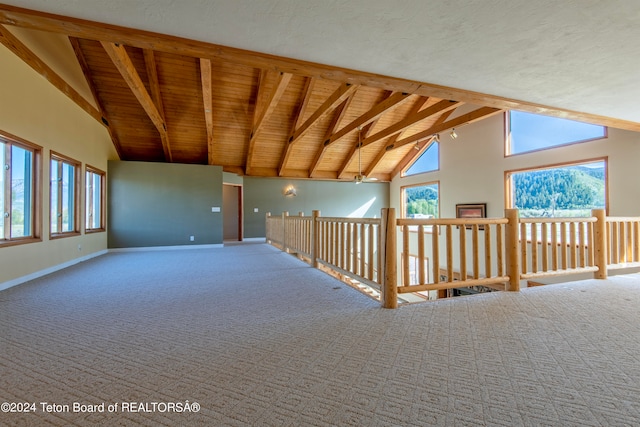 interior space with lofted ceiling with beams and a textured ceiling