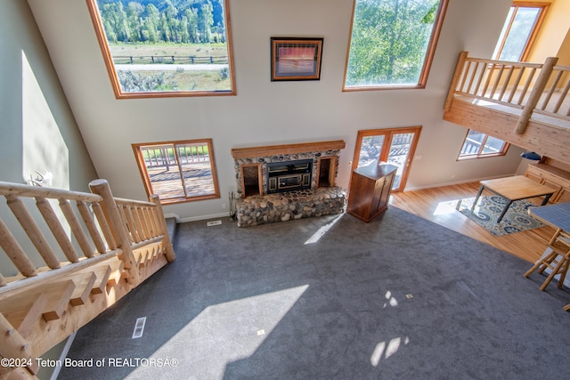 carpeted living room featuring a high ceiling and a fireplace