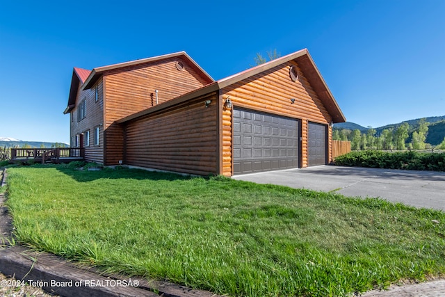 view of property exterior with a garage and a lawn