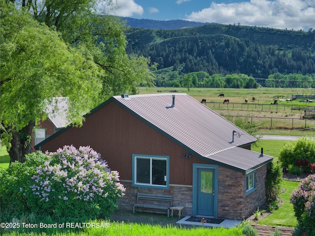 4193 Old Irwin Rd, Irwin, ID 83428 - back of property with stone siding, a standing seam roof, a metal roof, a mountain view, and a wooded view