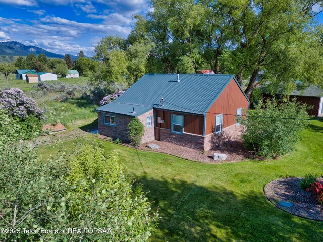 4193 Old Irwin Rd, Irwin, ID 83428 - rear view of house with stone siding, a lawn, and a metal roof
