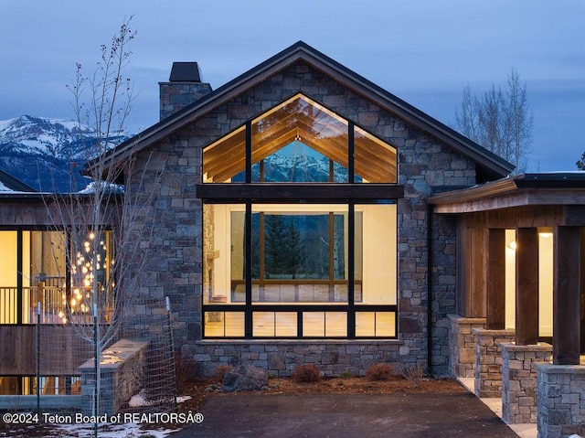 rear view of house with a chimney and a mountain view