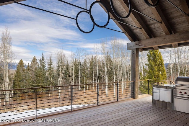 deck featuring a grill and a wooded view