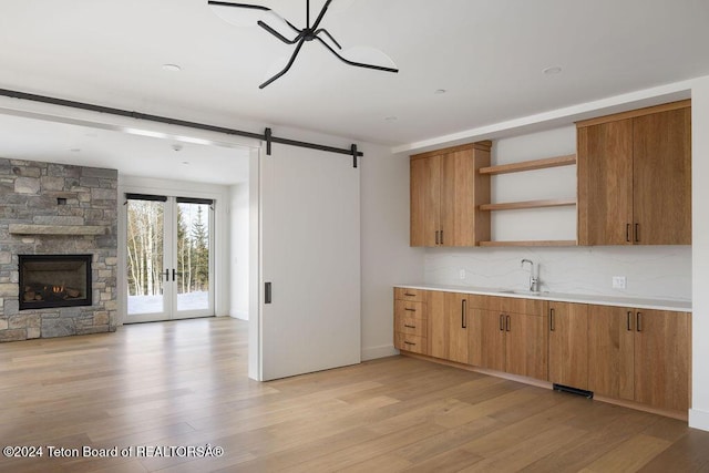 kitchen featuring light wood-style floors, open shelves, a sink, and open floor plan