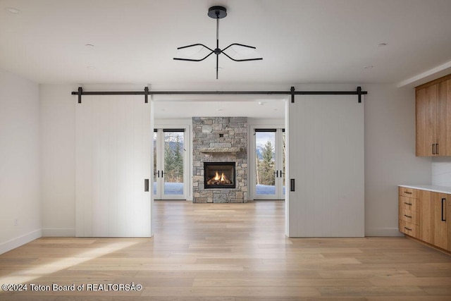 interior space with light wood-type flooring, open floor plan, and a barn door